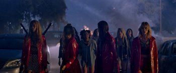 Movie still from “Assassination Nation” (2018), directed by Sam Levinson – A group of people standing in the dark; Wide shot, Over the shoulder angle
