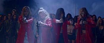 Movie still from “Assassination Nation” (2018), directed by Sam Levinson – A group of people dressed in red and holding guns; Medium shot, Low angle