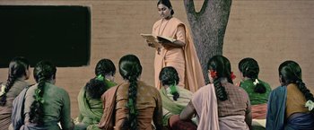 A group of women sitting around a tree reading a book