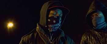 Movie still from “Attack the Block” (2011), directed by Joe Cornish – A man wearing a black hat and a black jacket; Close Up shot, Low angle