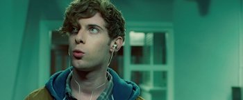 Movie still from “Attack the Block” (2011), directed by Joe Cornish – A young man wearing headphones looking up at the sky; Close Up shot, Over the shoulder angle