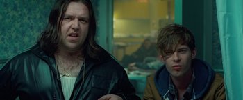 Movie still from “Attack the Block” (2011), directed by Joe Cornish – Two men are standing in a room with a table; Close Up shot, Over the shoulder angle