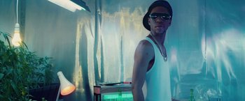 Movie still from “Attack the Block” (2011), directed by Joe Cornish – A man in a hat and sunglasses standing in a room; Medium shot, Low angle