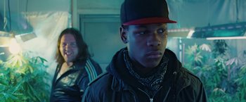 Movie still from “Attack the Block” (2011), directed by Joe Cornish – A young man wearing a red hat and a black jacket; Close Up shot, Over the shoulder angle