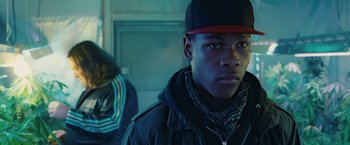 Movie still from “Attack the Block” (2011), directed by Joe Cornish – A young man wearing a baseball cap and a jacket; Close Up shot, Low angle