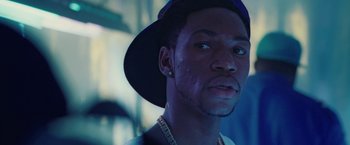 Movie still from “Attack the Block” (2011), directed by Joe Cornish – A person wearing a hat and looking at the camera; Close Up shot, Low angle