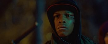 Movie still from “Attack the Block” (2011), directed by Joe Cornish – A young man wearing a black jacket and a red hat; Close Up shot, Low angle
