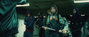 Movie still from “Attack the Block” (2011), directed by Joe Cornish – A group of young men standing next to each other holding baseball bats; Medium shot, Low angle