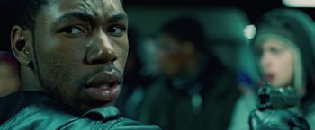 Movie still from “Attack the Block” (2011), directed by Joe Cornish – A man's face in a dark room; Close Up shot, Low angle