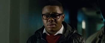 Movie still from “Attack the Block” (2011), directed by Joe Cornish – A person wearing glasses and a jacket; Close Up shot, Low angle