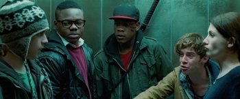 Movie still from “Attack the Block” (2011), directed by Joe Cornish – Two young men standing next to each other in front of a green wall; Close Up shot, Low angle