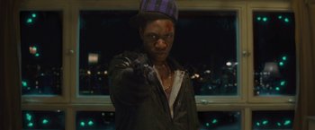 Movie still from “Attack the Block” (2011), directed by Joe Cornish – A man in a purple hat is holding a gun; Close Up shot, Overhead angle
