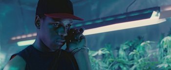 Movie still from “Attack the Block” (2011), directed by Joe Cornish – A man with a red hat is holding his hand to his face; Close Up shot, Low angle
