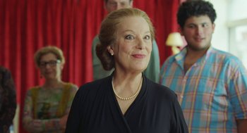 Movie still from “Attila Marcel” (2013), directed by Sylvain Chomet – An older woman in a black shirt and a group of people; Close Up shot, Low angle