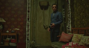 Movie still from “Attila Marcel” (2013), directed by Sylvain Chomet – A man standing in front of a wall holding a camera; Wide shot, High angle