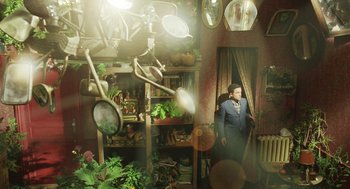 Movie still from “Attila Marcel” (2013), directed by Sylvain Chomet – A man standing in a room filled with potted plants; Wide shot, High angle