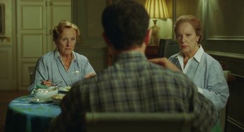 Movie still from “Attila Marcel” (2013), directed by Sylvain Chomet – Two women and a man are sitting at a table; Medium shot, Over the shoulder angle