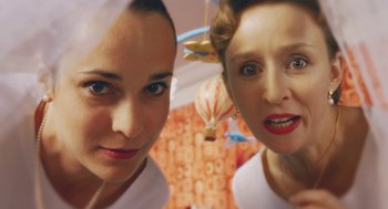 Movie still from “Attila Marcel” (2013), directed by Sylvain Chomet – Two women are posing for a picture in front of a hot air balloon; Close Up shot, Low angle