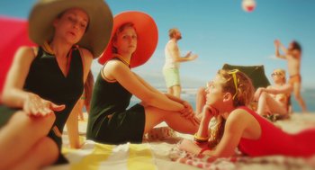 Movie still from “Attila Marcel” (2013), directed by Sylvain Chomet – A group of people sitting on top of a sandy beach; Medium shot, High angle