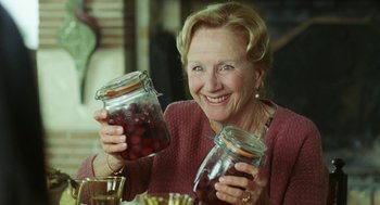 Movie still from “Attila Marcel” (2013), directed by Sylvain Chomet – An older woman holding a jar of cherries in front of her face; Close Up shot, Over the shoulder angle