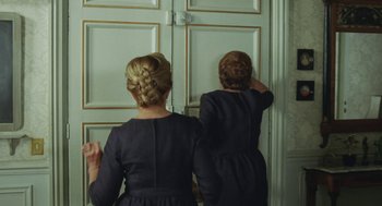 Movie still from “Attila Marcel” (2013), directed by Sylvain Chomet – Two women in black dresses looking in a mirror; Medium shot, Over the shoulder angle