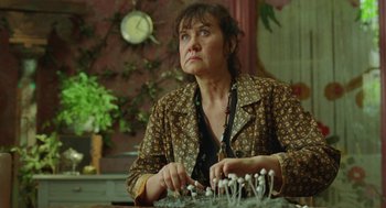 Movie still from “Attila Marcel” (2013), directed by Sylvain Chomet – A woman sitting at a table with a bunch of mushrooms on it; Close Up shot, Low angle