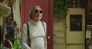 Movie still from “Attila Marcel” (2013), directed by Sylvain Chomet – An older man wearing sunglasses and a white turtleneck; Medium shot, Low angle