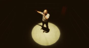 Movie still from “Attila Marcel” (2013), directed by Sylvain Chomet – A man in black and white striped shirt holding a microphone; Medium shot, Low angle