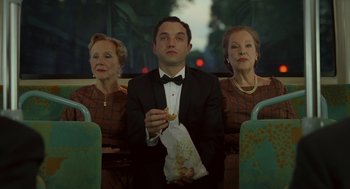 Movie still from “Attila Marcel” (2013), directed by Sylvain Chomet – A man in a tuxedo sitting on a bus while two women look on; Medium shot, High angle