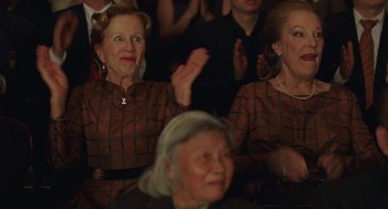 Movie still from “Attila Marcel” (2013), directed by Sylvain Chomet – Two older women sitting next to each other in front of an audience; Medium shot, Low angle