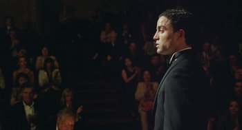 Movie still from “Attila Marcel” (2013), directed by Sylvain Chomet – A man standing in front of an audience in front of a crowd of onlookers; Medium shot, Low angle