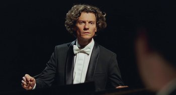 Movie still from “Attila Marcel” (2013), directed by Sylvain Chomet – A man in a suit and bow tie is standing in front of a piano; Close Up shot, Low angle
