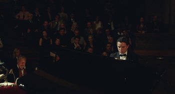 Movie still from “Attila Marcel” (2013), directed by Sylvain Chomet – A man sitting at a piano in front of an audience; Medium shot, High angle