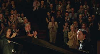 Movie still from “Attila Marcel” (2013), directed by Sylvain Chomet – A group of people standing in a room clapping; Wide shot, High angle