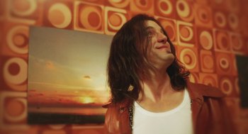 Movie still from “Attila Marcel” (2013), directed by Sylvain Chomet – A man with long hair is smiling at the camera; Close Up shot, Low angle