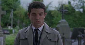 Movie still from “Attila Marcel” (2013), directed by Sylvain Chomet – A man wearing a suit and tie standing in front of a grave; Close Up shot, Over the shoulder angle