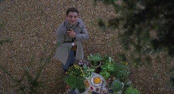 Movie still from “Attila Marcel” (2013), directed by Sylvain Chomet – A man standing in front of a table of food; Wide shot, Overhead angle