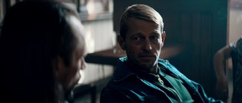 Movie still from “Avengement” (2019), directed by Jesse V. Johnson – A man sitting in front of another man in front of a window; Close Up shot, Over the shoulder angle