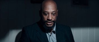 Movie still from “Avengement” (2019), directed by Jesse V. Johnson – A man in a suit and tie looking down; Close Up shot, Low angle