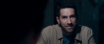 Movie still from “Avengement” (2019), directed by Jesse V. Johnson – A person sitting in a room; Close Up shot, Over the shoulder angle