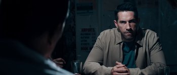 Movie still from “Avengement” (2019), directed by Jesse V. Johnson – A man sitting at a table in front of another man; Medium shot, Over the shoulder angle