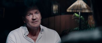 Movie still from “Avengement” (2019), directed by Jesse V. Johnson – An older man in a white dress shirt looking at the camera; Close Up shot, Over the shoulder angle