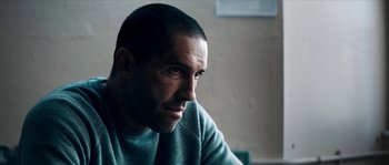 Movie still from “Avengement” (2019), directed by Jesse V. Johnson – A person sitting in a room; Close Up shot, Over the shoulder angle