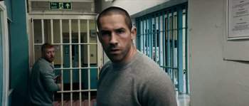 Movie still from “Avengement” (2019), directed by Jesse V. Johnson – A person standing in front of a jail cell; Close Up shot, Low angle