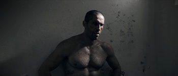 Movie still from “Avengement” (2019), directed by Jesse V. Johnson – A man with a beard is posing for a picture; Close Up shot, Low angle