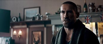 Movie still from “Avengement” (2019), directed by Jesse V. Johnson – A person with a towel around his neck; Close Up shot, Over the shoulder angle