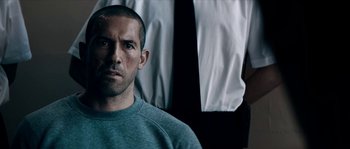 Movie still from “Avengement” (2019), directed by Jesse V. Johnson – A person wearing a sweatshirt; Close Up shot, Over the shoulder angle