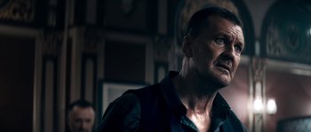 Movie still from “Avengement” (2019), directed by Jesse V. Johnson – A person in a dark room; Close Up shot, Over the shoulder angle