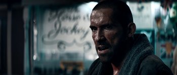 Movie still from “Avengement” (2019), directed by Jesse V. Johnson – A person with a face covered in dirt; Close Up shot, Over the shoulder angle
