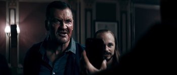 Movie still from “Avengement” (2019), directed by Jesse V. Johnson – A man taking a picture of himself and another man with a cell phone; Close Up shot, Over the shoulder angle